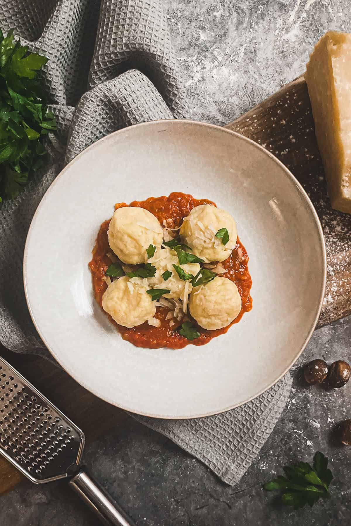 gnudi in a bowl with tomato sauce