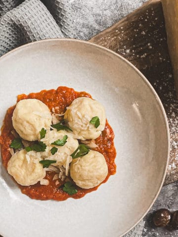 gnudi in a bowl with tomato sauce