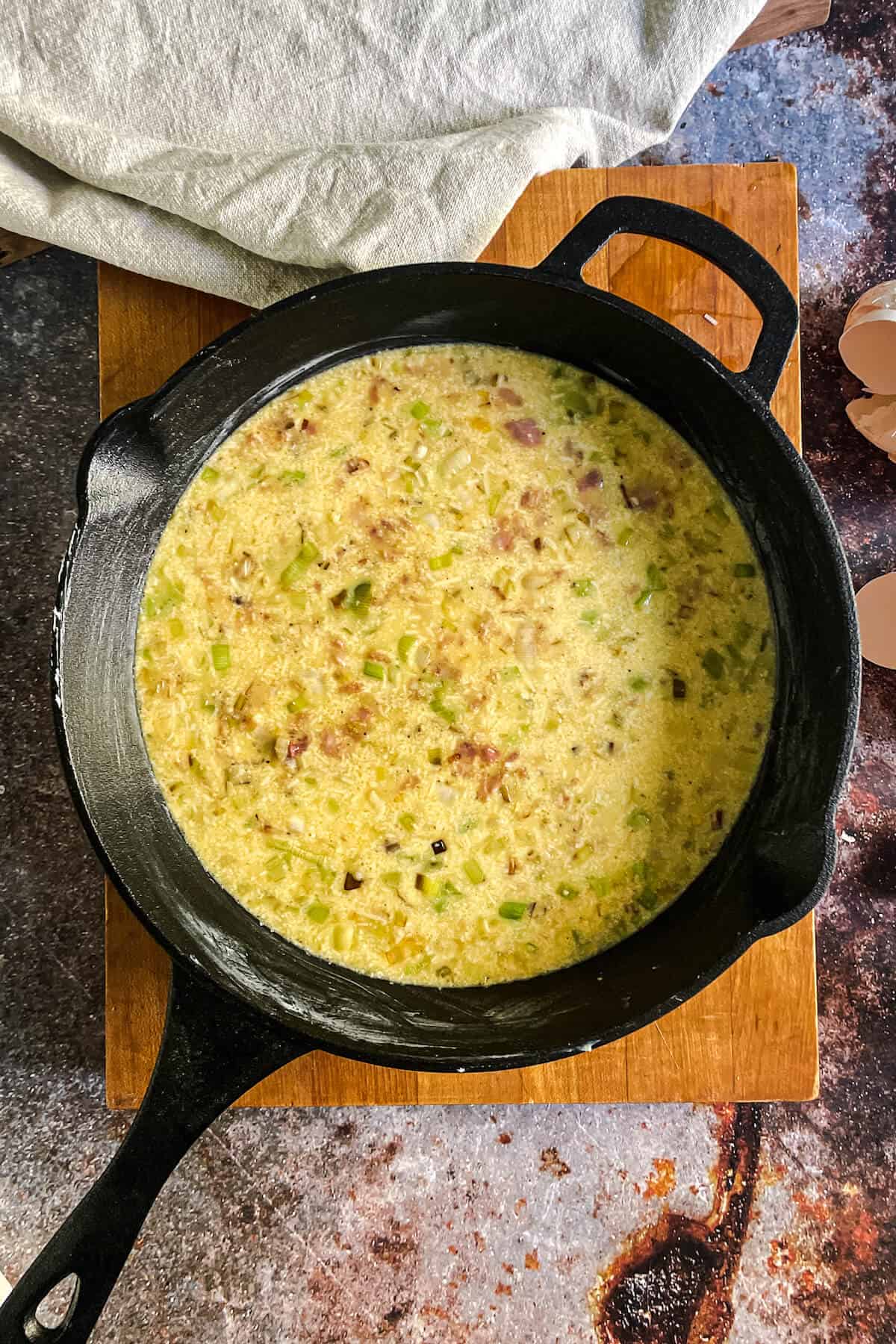 bacon and leek frittata ingredients in a cast iron skilet