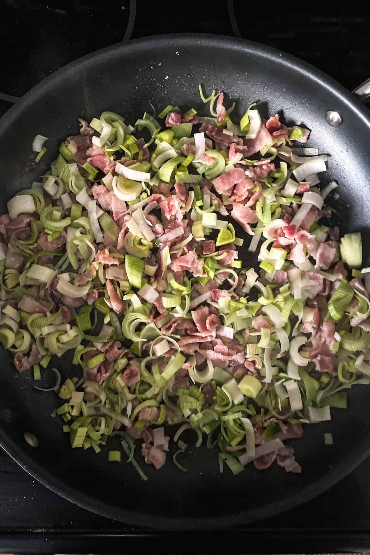 bacon and leek cooking in a pan