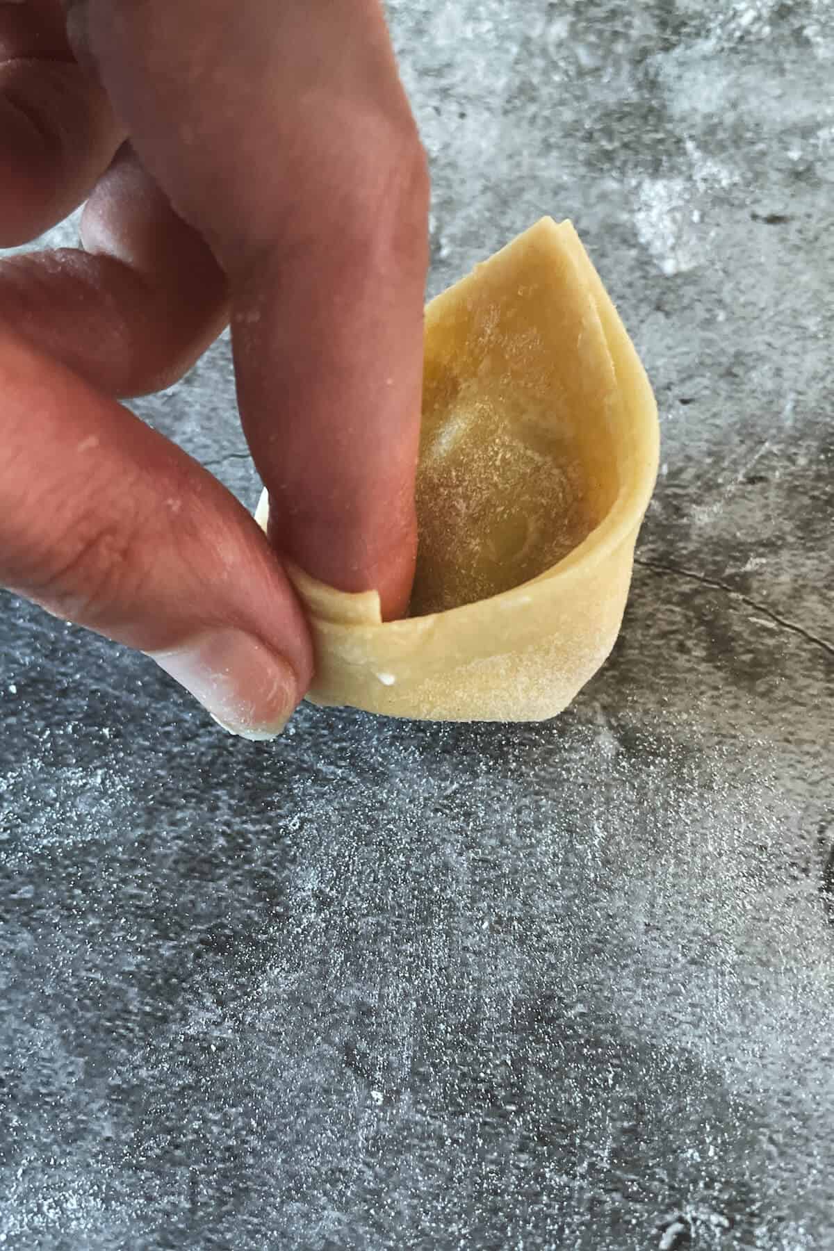hand shaping sausage and kale tortellini