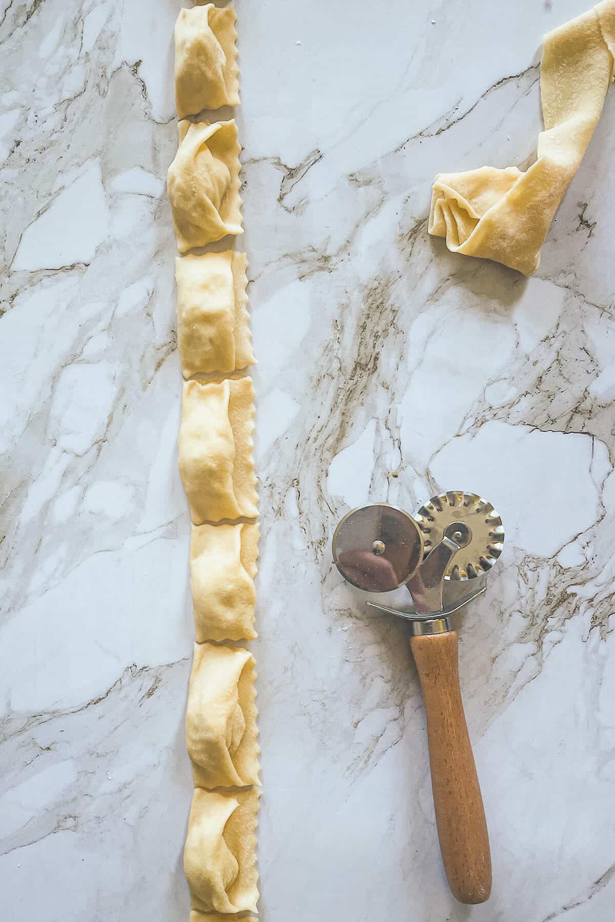 pasta wheel with agnolotti on a counter